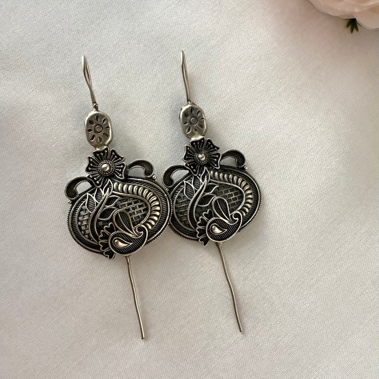 Pair of silver ear pins on a light background