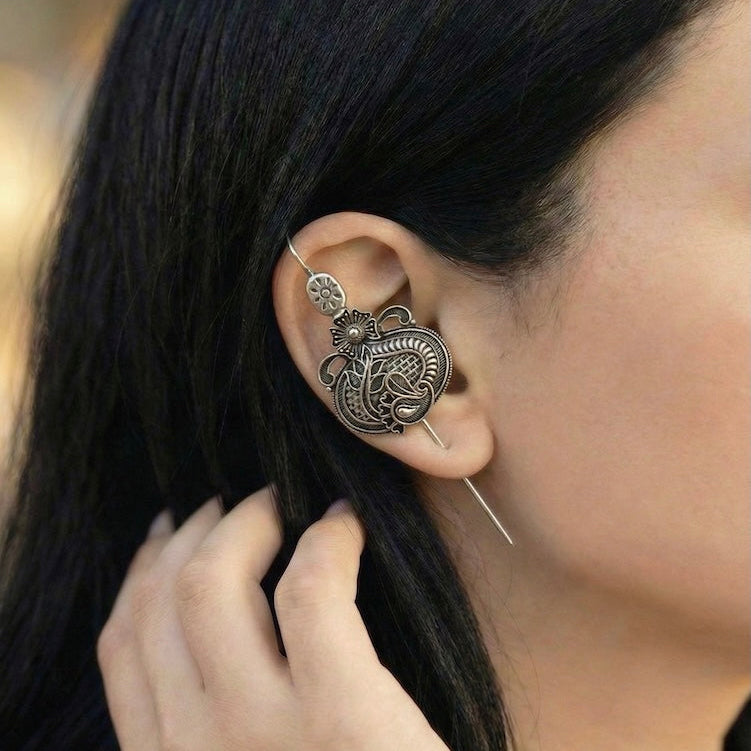 Close-up of an ornate ear pin.